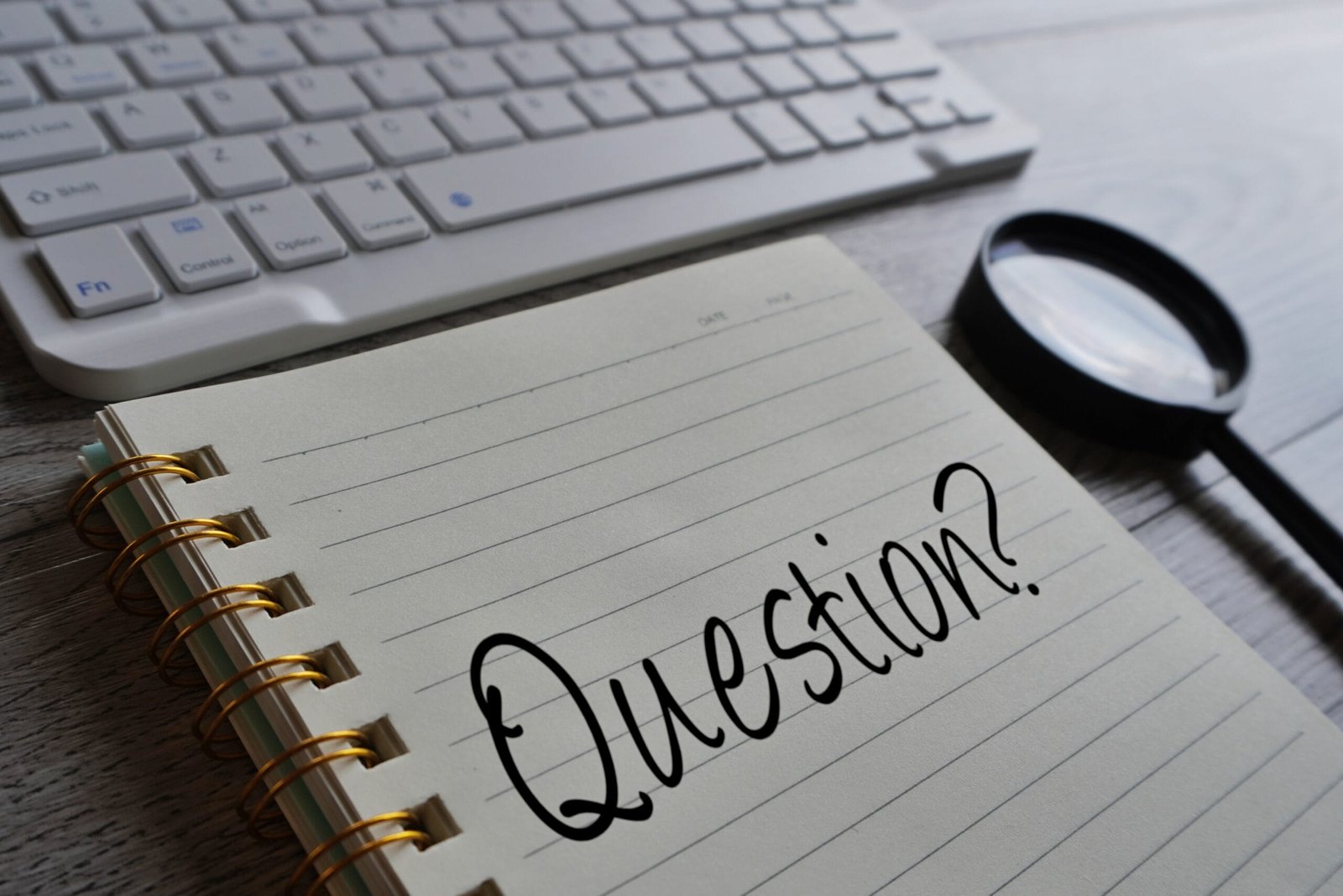 keyboard-magnifying-glass-question-written-out-on-notebook