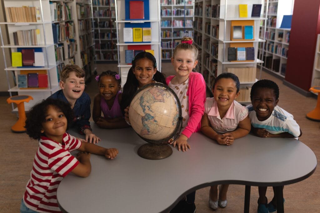 front-view-of-happy-schoolkids-with-globe-looking